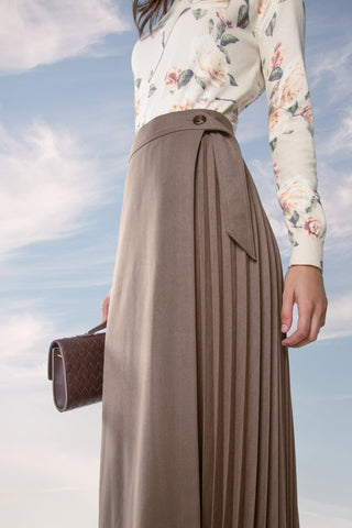 A model wearing MUN Mocha Cinder Pleated Wrap 35" Skirt at Dress Code itsdresscode.com